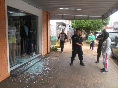 La propietaria del negocio visitado por los malvivientes, Cihthia Noemí Ortigoza, conversa con el jefe de la comisaría Cuarta, comisario principal Alcidez Quiñónez.