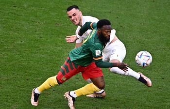 El camerunés Georges-Kevin Nkoudou (frente) lucha por la posesión del balón con el serbio Filip Kostic, durante el partido que disputaron ayer y que finalizó empatado a tres goles.