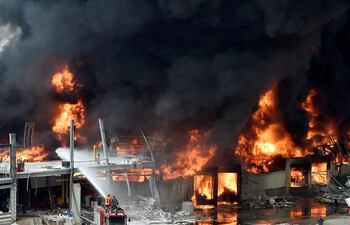 Bomberos libaneses intentan extinguir un incendio en un puerto de Beirut.