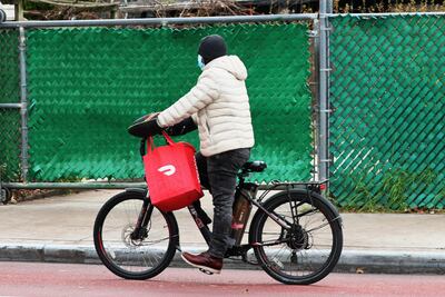 Un repartidor de comida para la aplicación Doordash pedalea su bicicleta eléctrica en Flatbush, Brooklyn, Nueva York.
