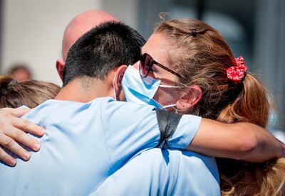 Trabajadores de un hospital en Bruselas, Bélgica, se abrazan durante un homenaje a uno de sus compañeros que falleció por COVID-19.