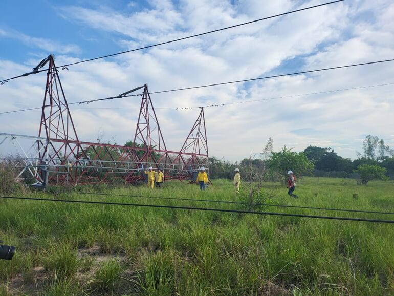 Técnicos de la ANDE que acompañaron al titular del ente, en la zona de la torre de alta tensión que se desplomó tras la tormenta del miércoles por la noche.