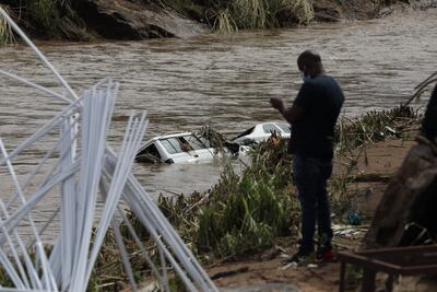 Una persona observa vehículos hundidos en una zona inundada cerca de Durba, Sudáfrica.