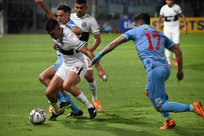 Brian Montenegro trata de llevarse el balón ante la marca de dos jugadores de Resistencia