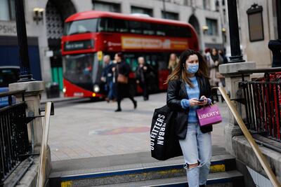 Una mujer con mascarilla baja a la estación de subte de Oxford Circus, en Londres.