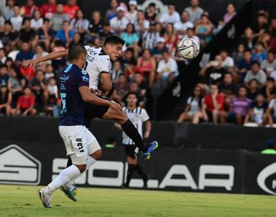El goleador liberteño Lorenzo Melgarejo conecta de cabeza el balón ante la marca del lateral Elías Brítez.