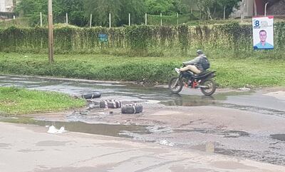 Los motociclistas y conductores deben sortear los baches en Molas López, que parece totalmente "bombardeada".