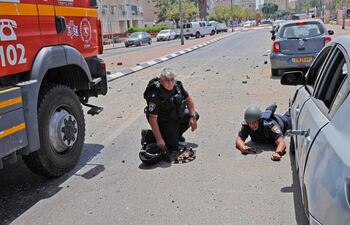 Miembros de las fuerzas de seguridad israelíes se tiran al suelo, mientras desde la franja de Gaza se lanzan cohetes, controlados por Hamas, en la ciudad de Ashkelon, Israel.