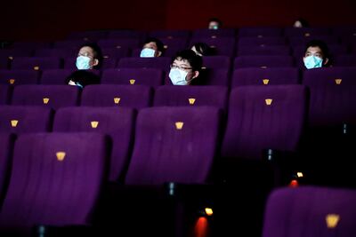 Varias personas ven una película en en un cine en Taipei, Taiwan. Taiwán ha aliviado las restricciones del nivel 3 de Covid-19 en Taipei.