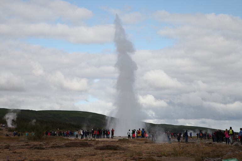 Turistas observan el géiser Strokkur en Islandia. La cantidad de visitantes fue creciendo en forma constante en los últimos años, hasta llegar a un punto en que se buscaba estabilizarla para mantener un turismo sustentable. Pero el coronavirus revirtió completamente la tendencia.