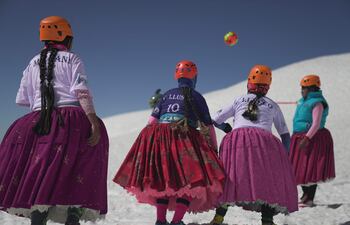 Un vendaval repentino silencia el crujido de los pasos en el hielo y hace ondear las faldas bajo la noche gélida. Diez mujeres aimaras escalan una montaña en los Andes bolivianos vistiendo su ropa tradicional como símbolo de liberación.