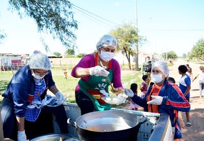 Las tres ciudadanas sirven las raciones en uno de los barrios habilitados por personas carenciadas en Concepción.