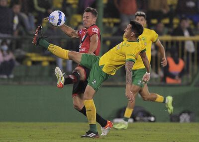 Nazareno Colombo (d), del equipo de Defensa y Justicia, rechaza el balón ante la presencia del argentino Diego Churín, ex Cerro Porteño y actual jugador del Atlético Goianiense.