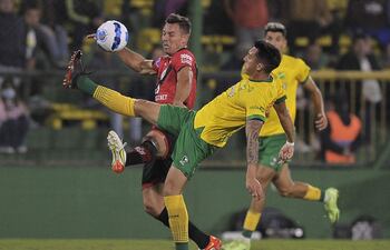 Nazareno Colombo (d), del equipo de Defensa y Justicia, rechaza el balón ante la presencia del argentino Diego Churín, ex Cerro Porteño y actual jugador del Atlético Goianiense.