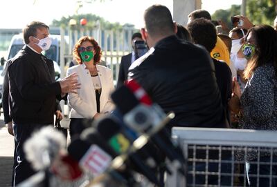 El presidente de Brasil, Jair Bolsonaro (izq.), dialoga con los periodistas y ciudadanos en las afueras del Palacio da Alvorada, en el marco de la crisis de la pandemia del covid-19.
