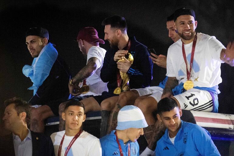 Los jugadores de la selección de Argentina a bordo del bus descapotable durante el recorrido hasta el predio de Ezeiza en compañía de miles y miles de argentinos, que recibieron al plantel en el Aeropuerto Internacional de Ezeiza después de la conquista del Mundial Qatar 2022. 