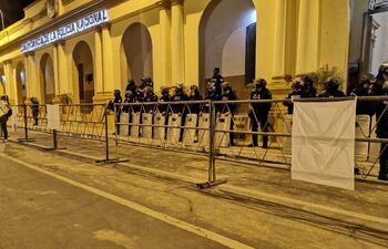 Antimotines vigilan la Comandancia tras un vallado con banderas blancas "de paz" ofrecidas por la propia Policía.