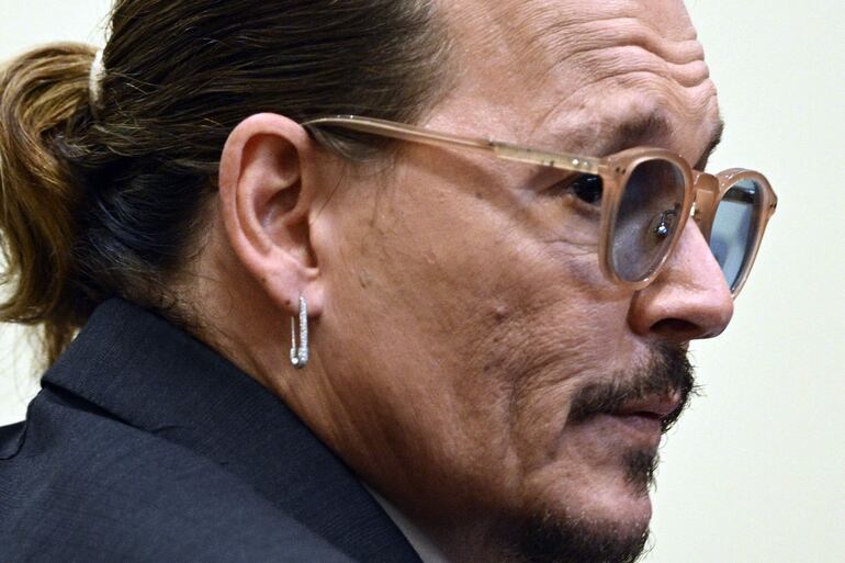 US actor Johnny Depp listens in the courtroom at the Fairfax County Circuit Courthouse in Fairfax, Virginia, for his defamation trial, on April 26, 2022. - Actor Johnny Depp sued his ex-wife Amber Heard for libel in Fairfax County Circuit Court after she wrote an op-ed piece in The Washington Post in 2018 referring to herself as a "public figure representing domestic abuse." (Photo by BRENDAN SMIALOWSKI / POOL / AFP)