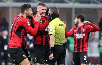 Ante Rebic y Olivier Giroud, jugadores del Milan, reclaman al árbitro Marco Serra un error en el partido contra Spezia.