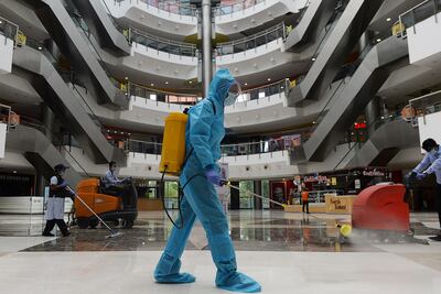Un trabajador sanitiza el piso de un mall en Chennai, India. Es una medida contra la propagación del coronavirus.