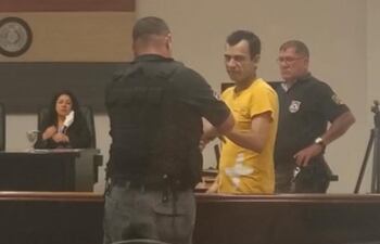 Carlos Armoa Escobar, siendo esposado por un guardiacárcel.