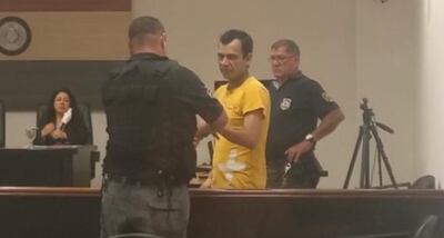 Carlos Armoa Escobar, siendo esposado por un guardiacárcel.