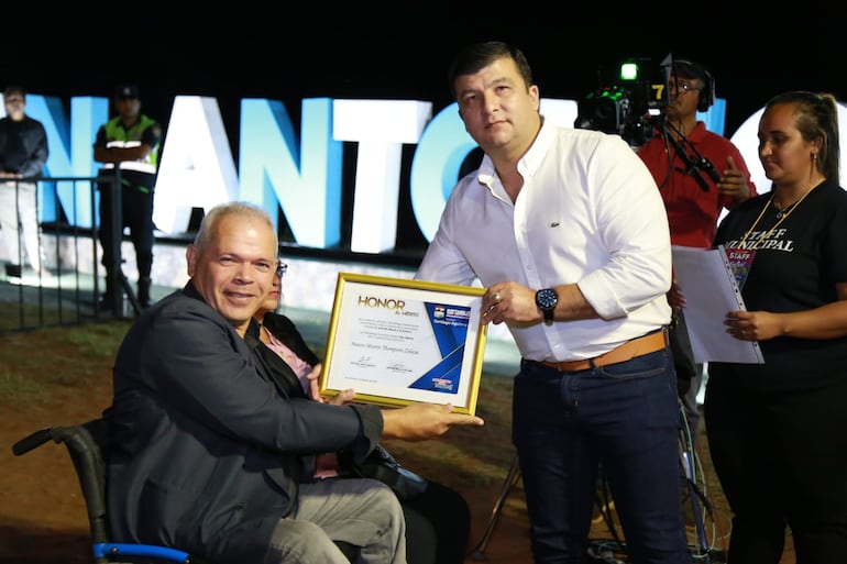 El dibujante, Mauro Thompson, fue declarado hijo dilecto de la ciudad de San Antonio por la intendencia local. El jefe comunal, Santiago Aguilera, entrega el reconocimiento.