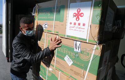 Un obrero palestino procede a la descarga de un cargamento de vacunas de Sinopharm en Nablus, en la Franja de Gaza.