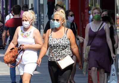 Los ciudadanos usan mascarillas mientras caminan por una calle de Bruselas el 12 de agosto de 2020, mientras la capital belga impone medidas para frenar la propagación del COVID-19.
