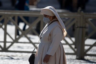 Una monja con mascarilla camina en la Plaza de San Pedro, en el Vaticano.