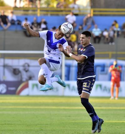Walter Cabrera se anticipa en el duelo aéreo a Gustavo Caballero, de Nacional, que no le pudo ganar ayer a Ameliano con un hombre más.