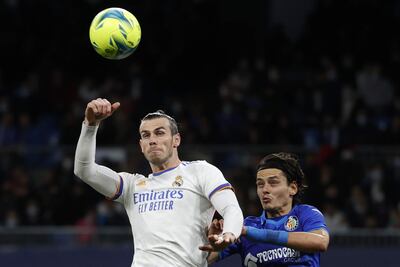 El delantero del Real Madrid Gareth Bale (i) salta a por un balón ante Enes Unal, del Getafe, durante el partido de Liga en Primera División que disputan este sábado en el estadio Santiago Bernabéu, en Madrid.