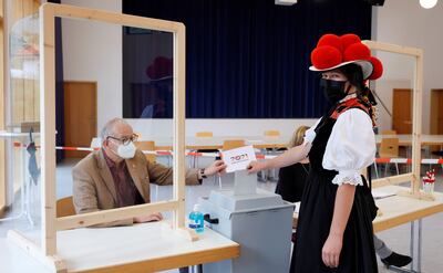 Una mujer que viste el traje típico de la Selva Negra alemana vota en una estación en Gutach, Alemania.