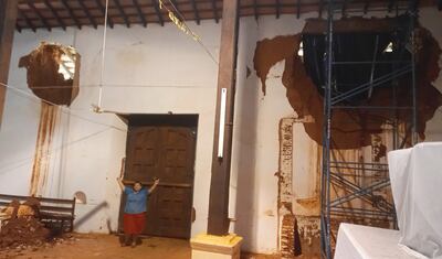 Una feligresa muestra los boquetes en la pared de la iglesia. El de la izquierda es el segundo formado hace unos días.