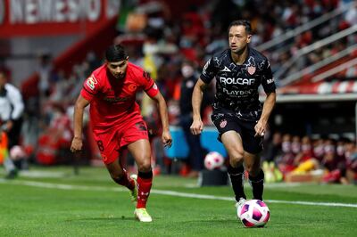 El zaguero paraguayo Julio González (d), del Necaxa, gana la posesión del balón ante Kevin Castañeda, del Toluca.