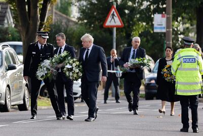 Autoridades británicas llevan tributos florales en memoria del legislador conservador británico David Amess, en la Iglesia Metodista de Belfair en Leigh-on-Sea, un distrito de Southend-on-Sea, en el sureste de Inglaterra.