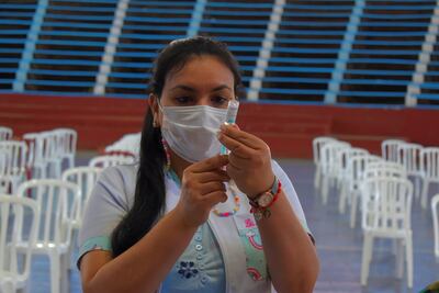 Funcionaria de blanco del Hospital Regional de Villarrica preparando la vacuna contra el COVID-19 para la inoculación.