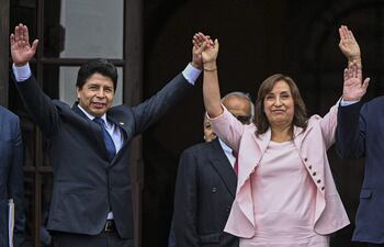 En esta foto de archivo tomada el 21 de noviembre de 2022, el presidente peruano Pedro Castillo (izquierda) saluda a los medios junto a la vicepresidenta Dina Boluarte.