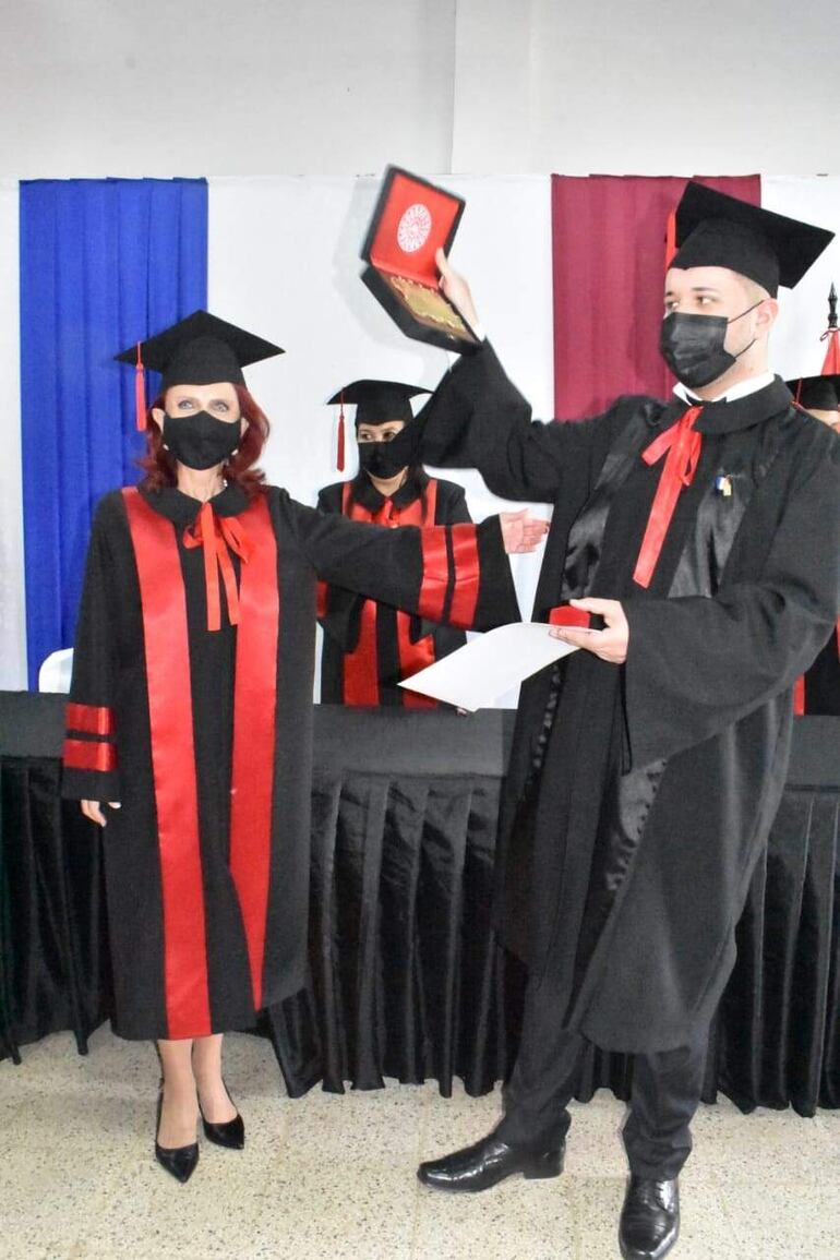 El mejor egresado Martín Fernando Alcaraz muestra una placa en la que se valora su logro.