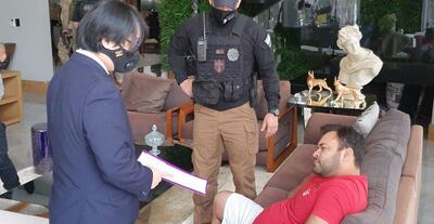 El fiscal Denny Yoon Pak (izq.) explica el procedimiento a Julio César Duarte, durante el operativo Status.