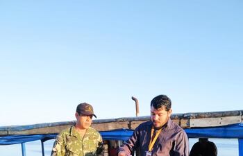 Momento en que el director de la Marina Mercante, Patricio Ortega, explica la disposición que deja sin efecto el cobro del canon a los lancheros a un oficial de guardia de la Marina paraguaya.