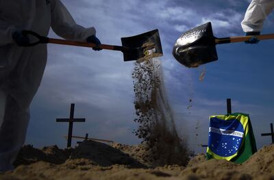 Activistas de la organización Río de Paz cavan cien tumbas simuladas en la playa de Copacabana para llamar la atención sobre las muertes por coronavirus.