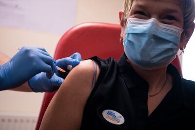 Una enfermera con un prendedor que reza "Yo me vacuno y te protejo" recibe una dosis de la vacuna Pfizer/BioNTech durante la campaña de vacunación en 
 el Centro Hospitalario Bretagne Atlantique, en Vannes, Francia.
