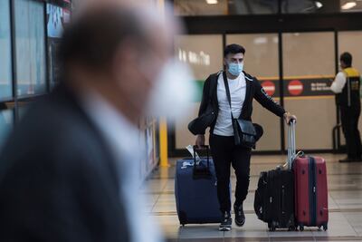 Viajeros con mascarillas llegan al aeropuerto Arturo Merino Benítez de Santiago, Chile.