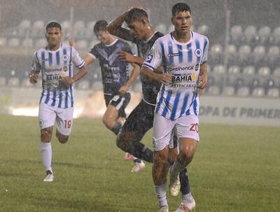 Los jugadores se disponen a abandonar el terreno de juego, luego de la intensa lluvia caída en Itauguá.