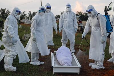 Trabajadores desinfectan un ataúd de una víctima de Covid-19 antes del entierro en Kuala Selangor, en las afueras de Kuala Lumpur, Malasia.