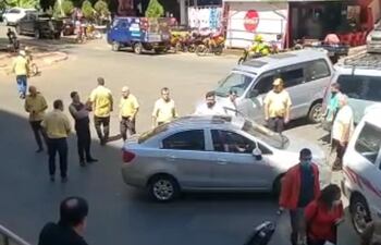 Taxistas rodean al conductor a quien los conductores de transporte alternativo cerraron el paso. uno de los taxista atacó{ó con un palo de madera.