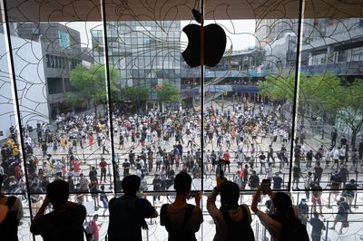 Cientos de personas forman fila para entrar a la nueva tienda de Apple en Pekín, la más grande de esta marca en Asia.