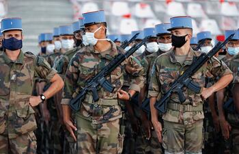 Soldados franceses del 2º Regimiento de Dragones, que trabajaron durante el nuevo coronavirus, la pandemia COVID-19, usan máscaras faciales mientras practican su formación de marcha antes del Desfile del Día de la Bastilla.