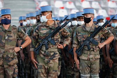 Soldados franceses del 2º Regimiento de Dragones, que trabajaron durante el nuevo coronavirus, la pandemia COVID-19, usan máscaras faciales mientras practican su formación de marcha antes del Desfile del Día de la Bastilla.